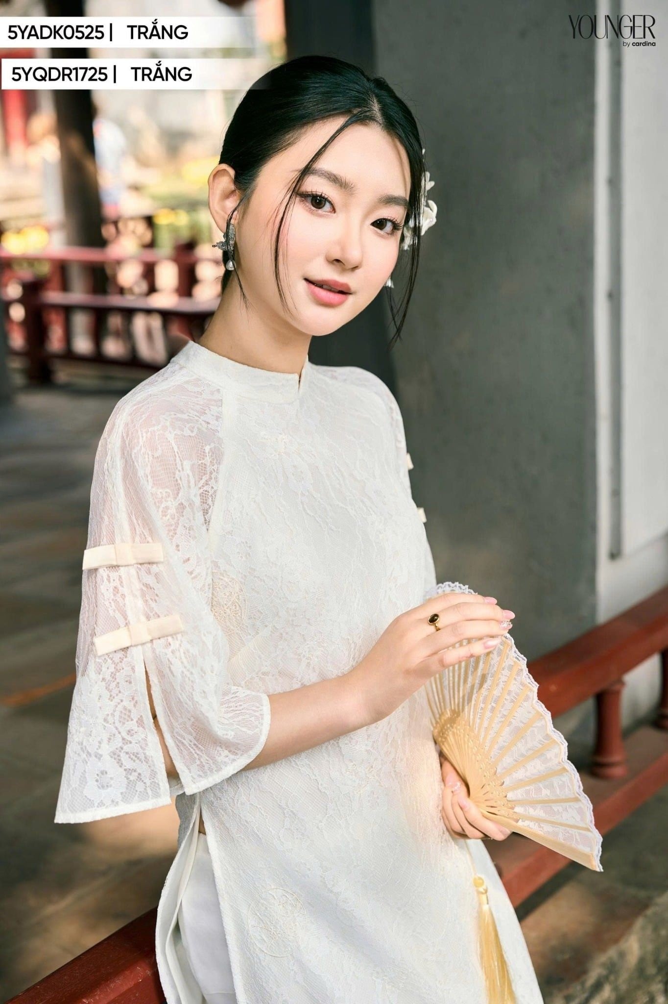 Cầm quạt che trước ngực, mắt nhìn ống kính, mỉm cười duyên dáng, góc chụp cận cảnh