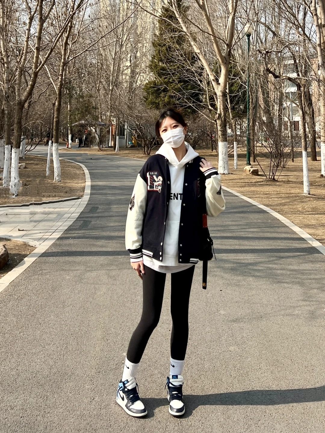 25. Áo khoác varsity + Hoodie trắng + Quần legging + Giày Jordan 1 