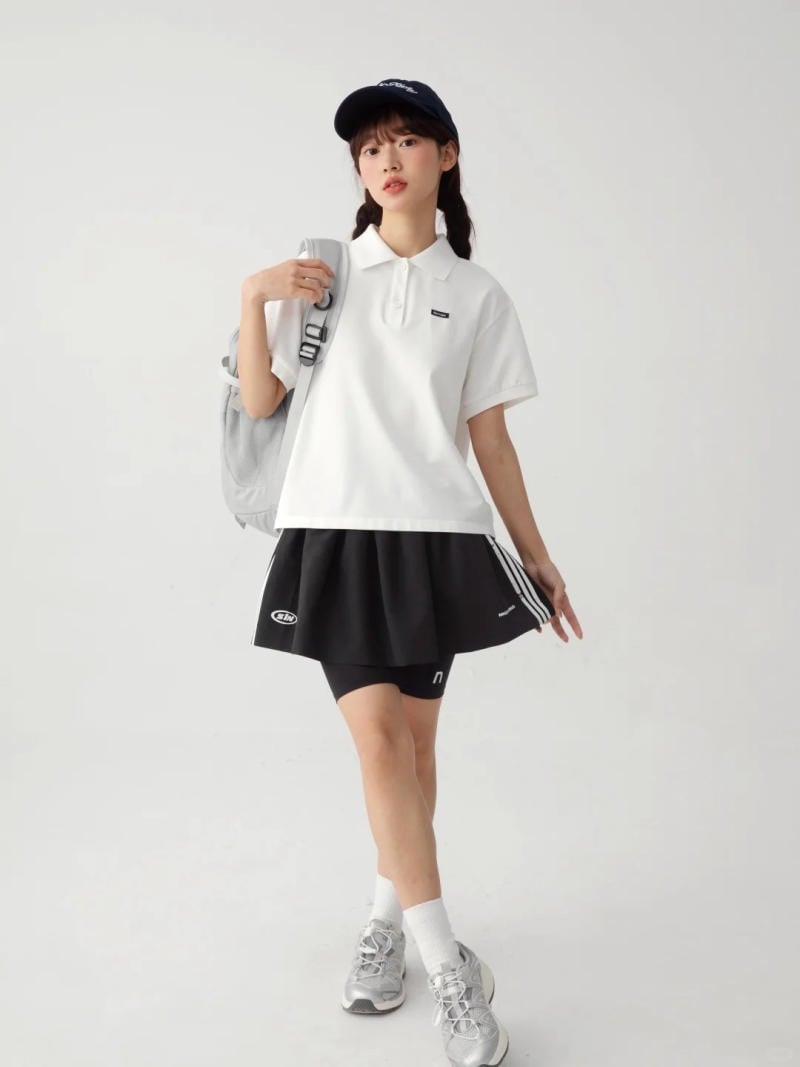11. Áo polo trắng form rộng + Chân váy xếp ly phối quần biker (skort) + Giày bạc