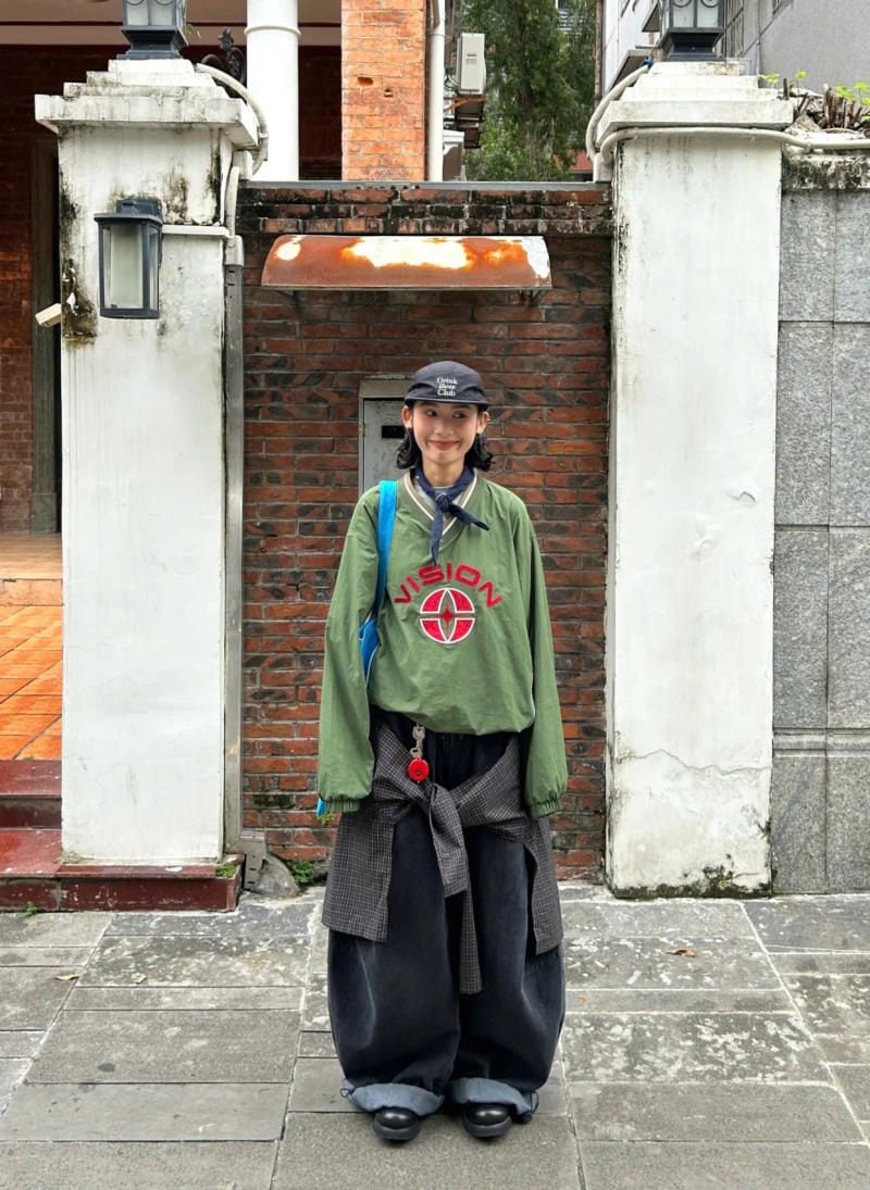 Quần ống cong màu xám đậm phối layer cùng sweatshirt xanh và áo sơ mi caro buộc eo