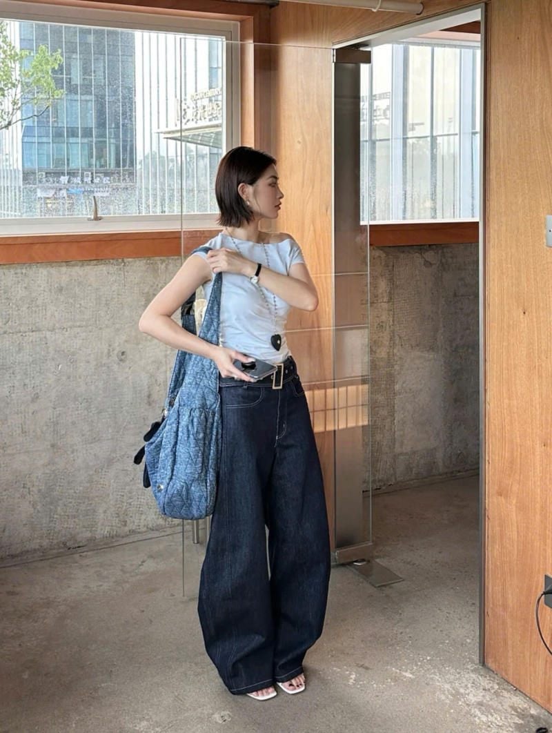 Quần jeans ống cong màu chàm đậm phối ton-sur-ton cùng áo kiểu và túi denim