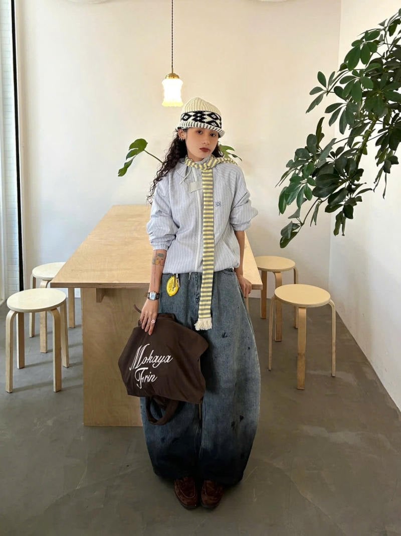 Quần jeans ống cong loang màu phối họa tiết cùng áo sơ mi và khăn choàng sọc