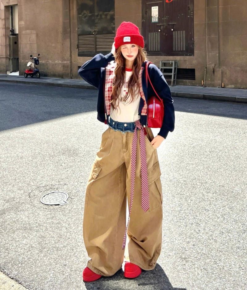 Quần cargo ống cong màu kaki phối layer cùng áo khoác và phụ kiện đỏ