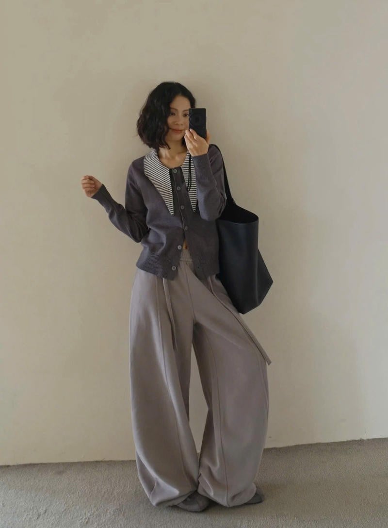 Quần ống cong màu xám phối cùng áo cardigan và sơ mi kẻ sọc