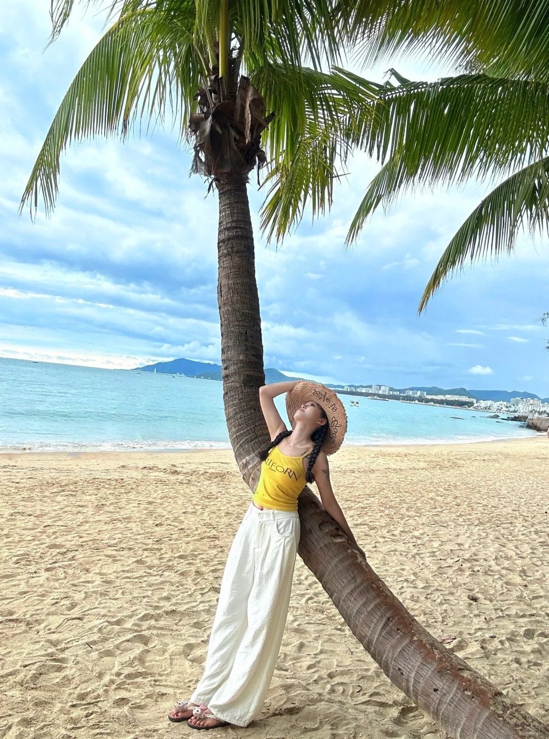 1. Tư thế tựa người vào thân dừa, mắt nhìn xa xăm