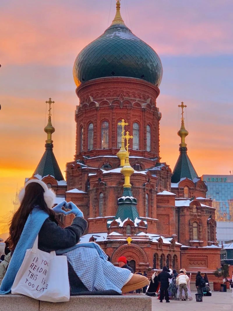 Ngồi quay lưng, tay tạo hình trái tim hướng về hoàng hôn