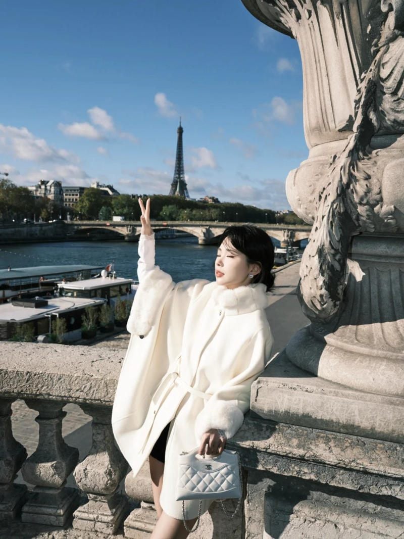 Tựa lưng vào lan can, giơ tay che nắng đầy mộng mơ