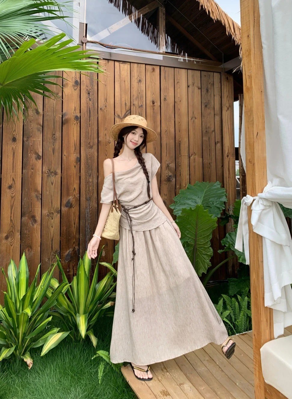 14. Đứng nghiêng người cười tươi (tay giữ quai túi, tạo dáng trước background gỗ)