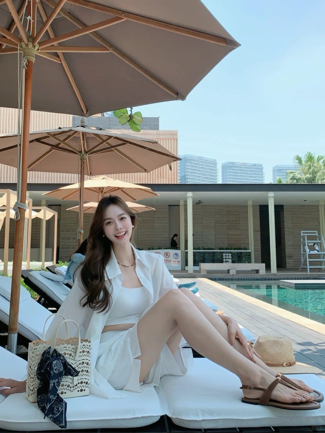 17. Ngồi duỗi chân trên ghế tắm nắng (cười rạng rỡ, khoe trọn vóc dáng)