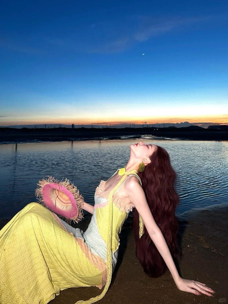 26. Dáng ngồi ngả người ra sau trên bãi cát hoàng hôn