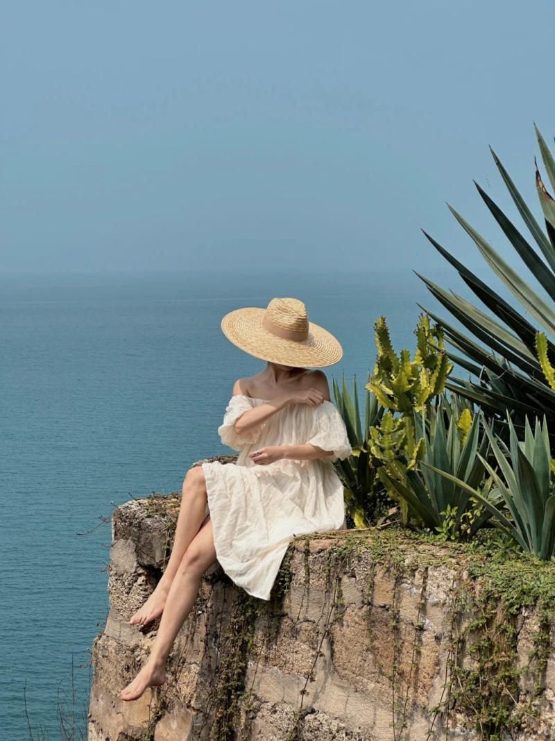 24. Dáng ngồi vắt chéo chân trên vách đá, mũ che mặt