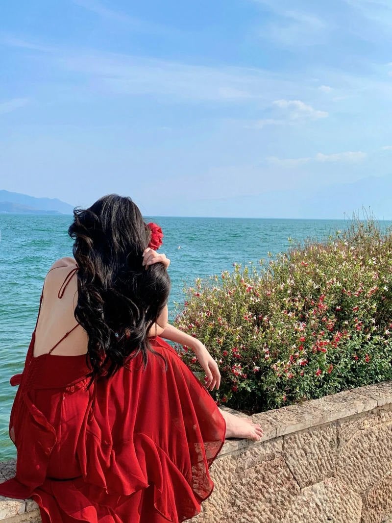 13. Dáng ngồi quay lưng trên bờ kè, tay vuốt tóc cài hoa