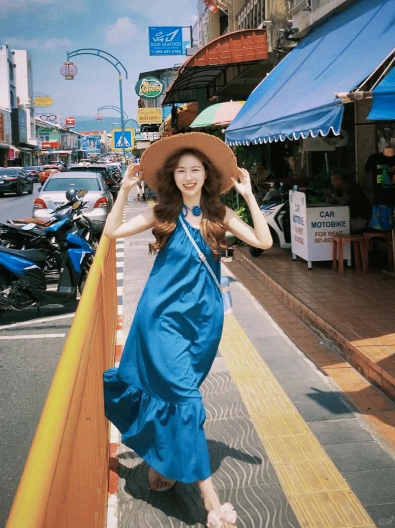 3. Dáng bước đi trên phố, hai tay giữ vành mũ cười tươi