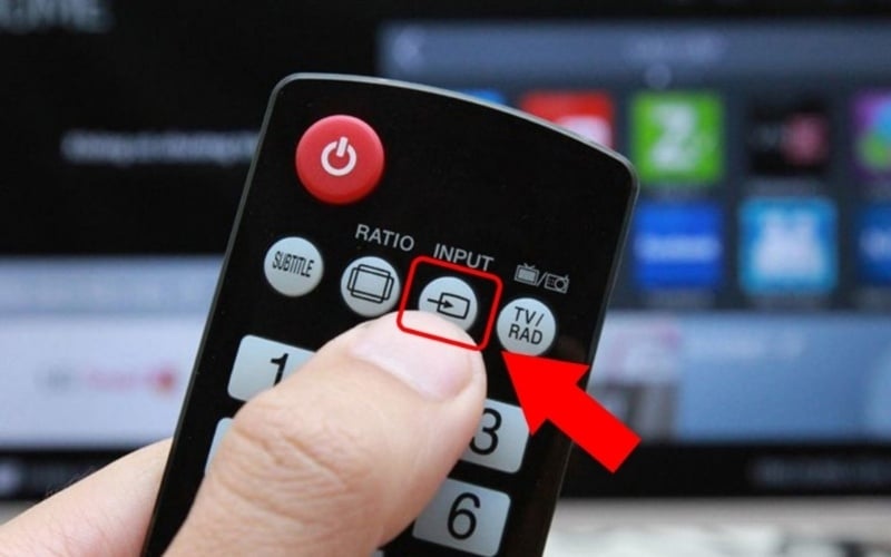 Bật tivi và dùng remote, nhấn nút Source/Input