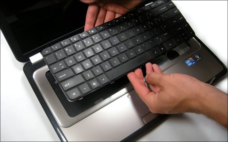 Mở các chốt cáp rồi nhấc bàn phím cũ ra khỏi máy