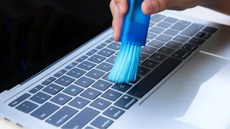 Dùng cọ quét sạch bụi trên bề mặt và giữa các kẽ phím