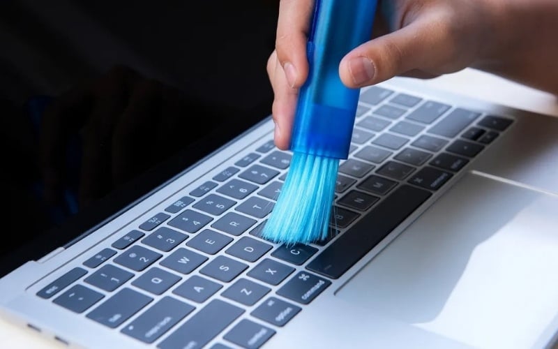 Dùng cọ quét sạch bụi bẩn nằm giữa các khe phím