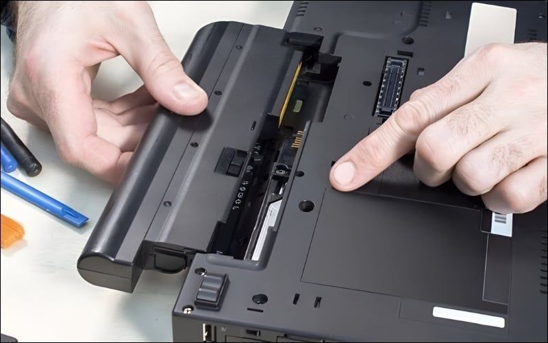 Rút sạc và tháo pin laptop để chuẩn bị xả điện tích dư