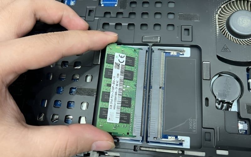 Tháo thanh RAM để chuẩn bị vệ sinh khe cắm