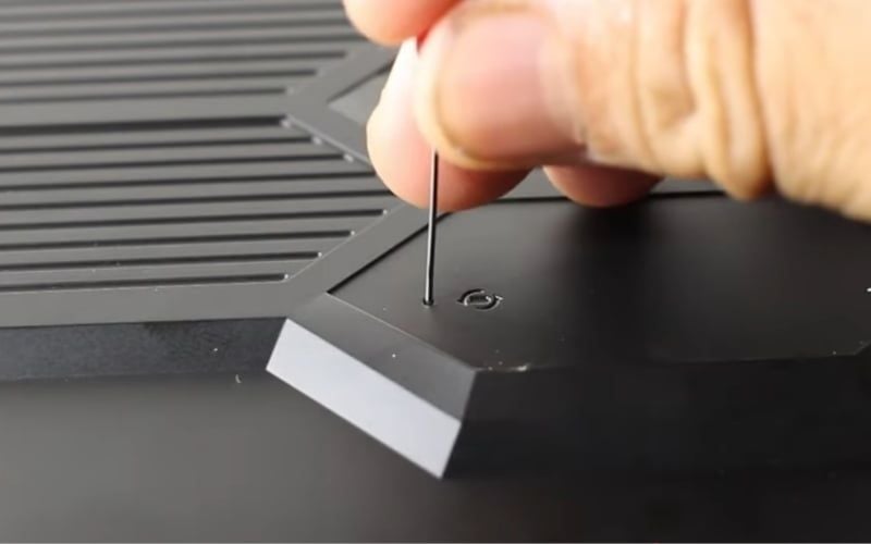 Ấn và giữ kim tại lỗ nhỏ có&nbsp;biểu tượng viên pin bên cạnh trong 15 giây