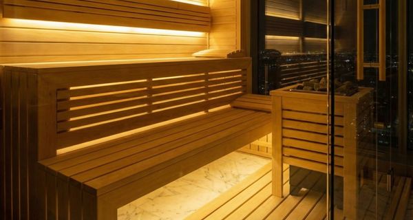 Hệ thống đèn LED hắt sáng nghệ thuật gầm ghế trong phòng xông hơi hiện đại.