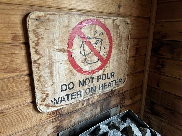 Biển báo cấm tưới nước lên máy xông hơi - dấu hiệu của sauna kém chất lượng.