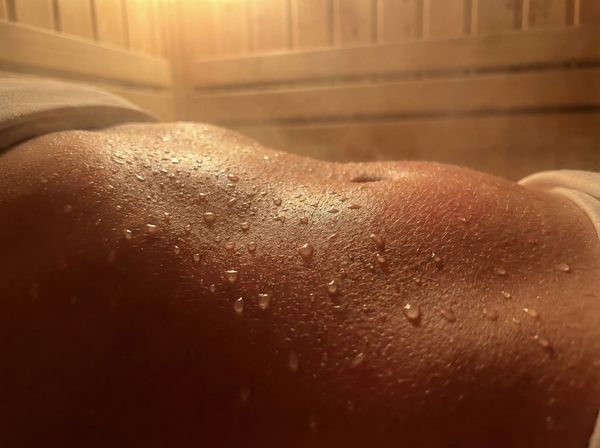 Cận cảnh đổ mồ hôi nhiều ở vùng bụng khi ngồi trong phòng xông hơi nhiệt độ cao.