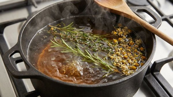 Nồi nước lá xông thảo dược đang sôi để lấy nước cốt.