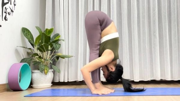 Động tác cúi người tay chạm bàn chân kéo giãn chân thon và thẳng hơn