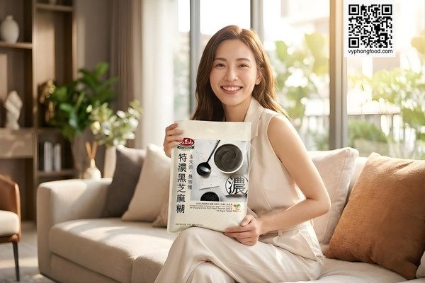 Người phụ nữ trẻ dáng thon gọn đang cầm túi Bột ngũ cốc dinh dưỡng từ mè đen Greenmax Đài Loan loại không đường, ngồi thư giãn trong phòng khách hiện đại.