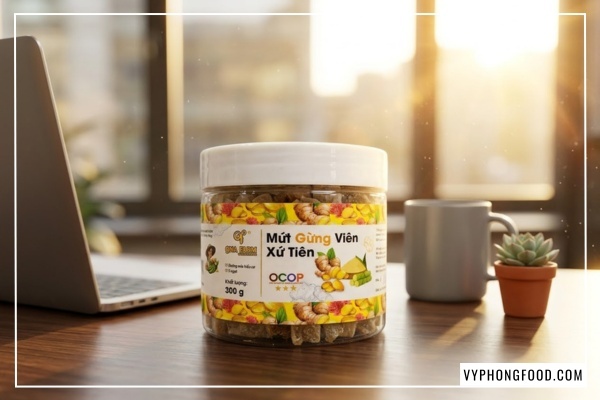 Cận cảnh hũ mứt gừng viên giòn QNA Farm 95g trên bàn làm việc, món snack gừng healthy giòn xốp ít đường cho dân văn phòng.