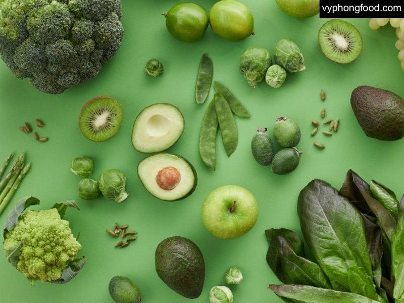 Ảnh bột ngũ cốc dinh dưỡng pha sẵn trong ly, kèm tô ngũ cốc – hạt nguyên liệu (yến mạch, đậu, mè, hạt lanh, óc chó) trên nền sáng; minh họa giải pháp đủ đạm thực vật cho người ăn chay.