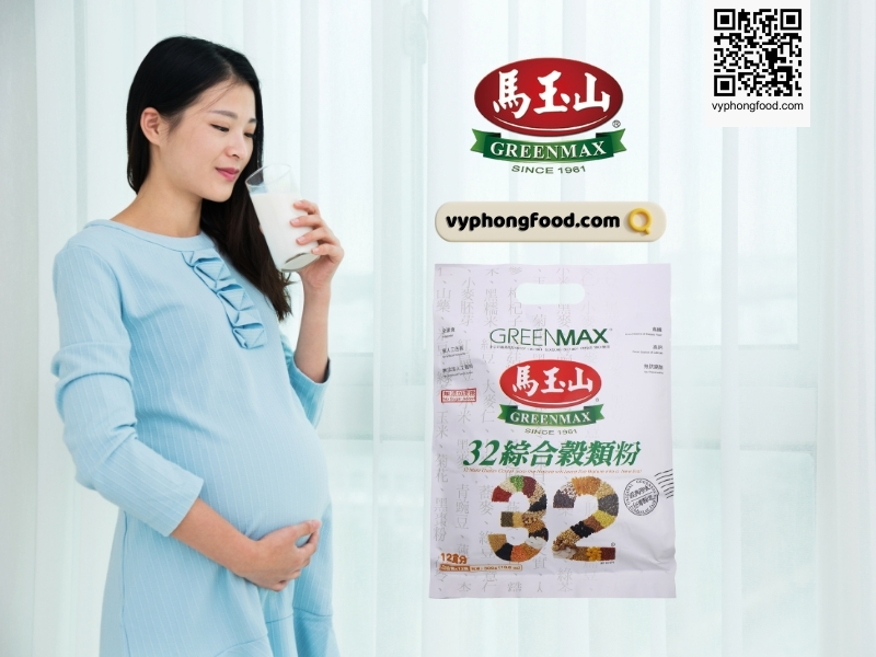 Young pregnant woman sitting at a table reading a prenatal guide about how to drink nutritional cereal powder for pregnant women; Greenmax product guidance and vyphongfood.com branding visible.
