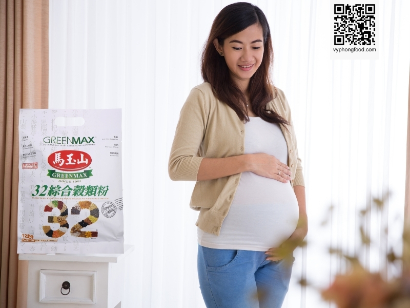 Young pregnant woman reviewing information about Greenmax prenatal nutritional cereal on a screen