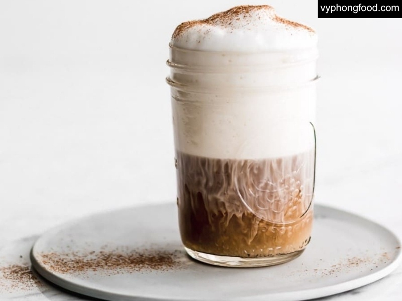 Festive Easter spread featuring South African Rooibos Tea in African Dawn teabags beside carrot cake, hot cross buns, and a chocolate latte—caffeine-free herbal tea, sleep-friendly, family-approved.