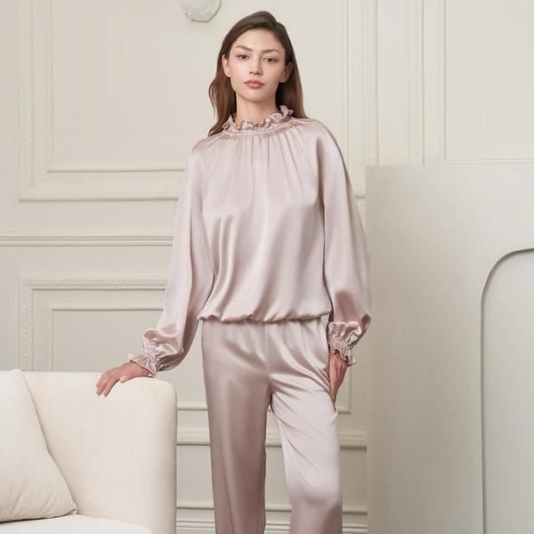 cô gái mặc bộ pyjama satin đứng thư thái trong phòng ngủ