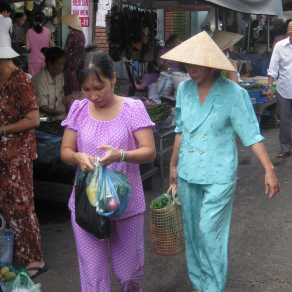 ladies in traditional vietnamese pajamas walking in the street