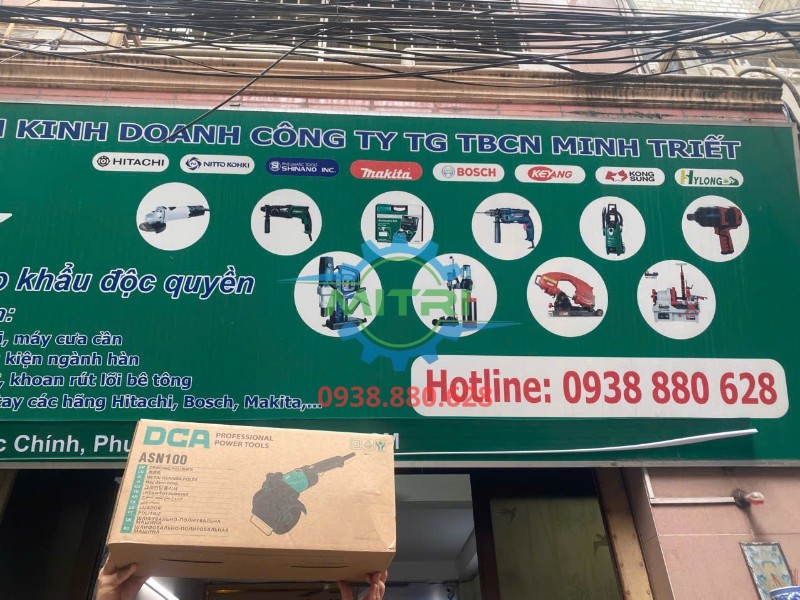 Máy đánh xước inox DCA ASN100 giơ cao trước bảng hiệu