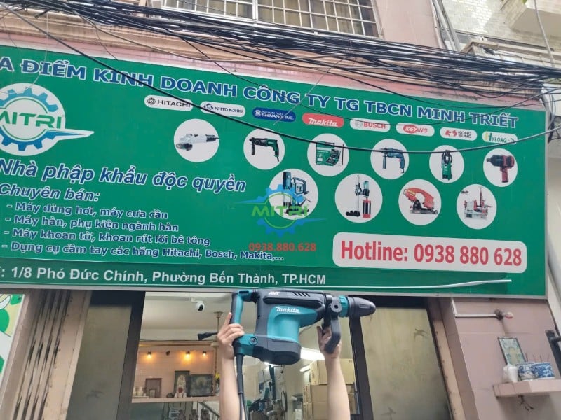 Máy đục bê tông Makita HM1213C trưng bày trước bảng hiệu Minh Triết