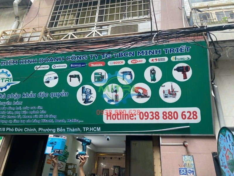 Máy khoan búa Makita DHP459Z thực tế trước bảng hiệu Minh Triết