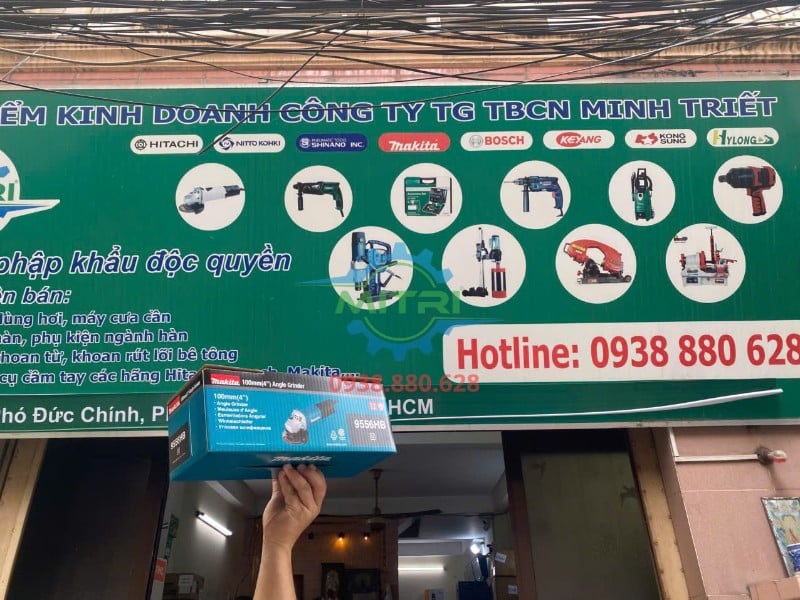Máy mài Makita 9556HB thực tế trước bảng hiệu Minh Triết