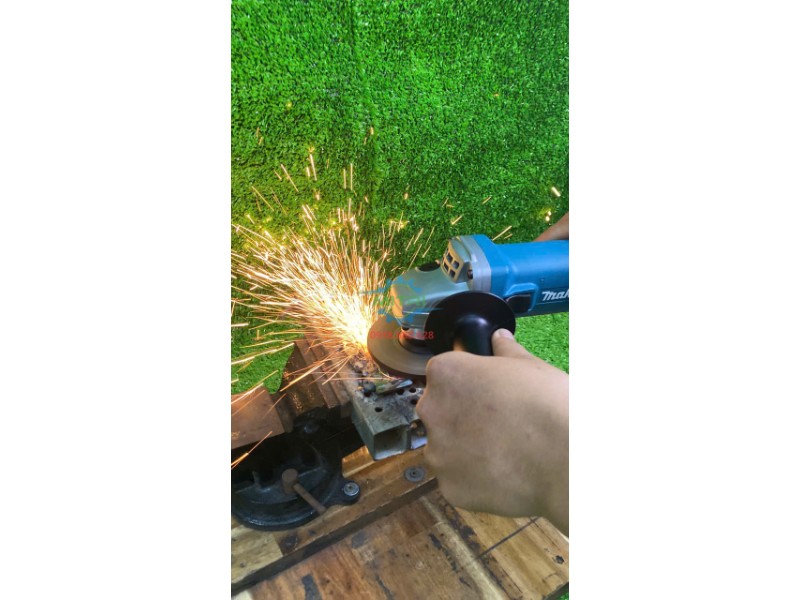 Makita 9556HN trong hình ứng dụng với kim loại và tia lửa