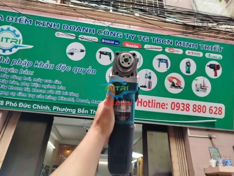 Máy mài góc Makita GA4040C trưng bày trước bảng hiệu Minh Triết