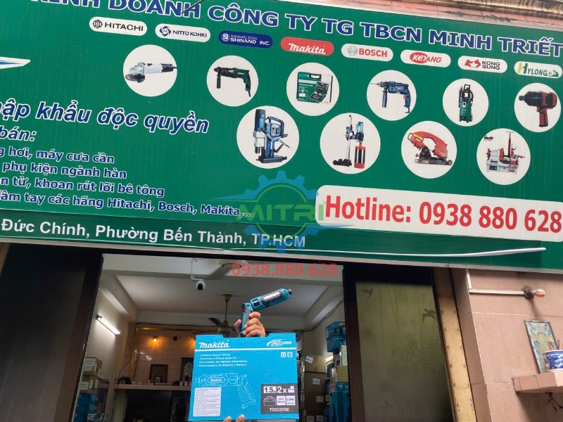 Máy vặn vít Makita TD022DSE và hộp sản phẩm thực tế trước bảng hiệu