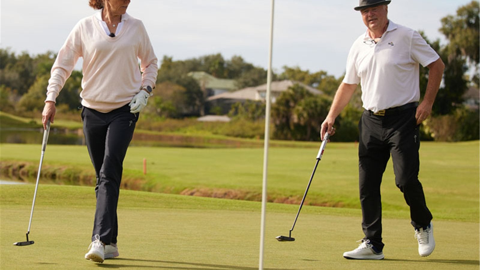 Hai golfer mang giày sáng màu trên mặt sân cỏ