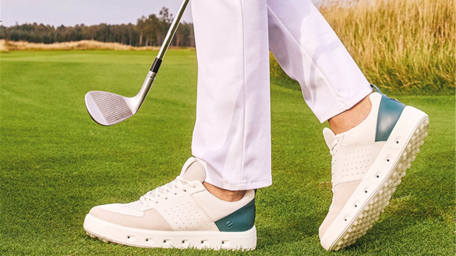 Giày golf trắng xanh phối quần sáng màu trên sân