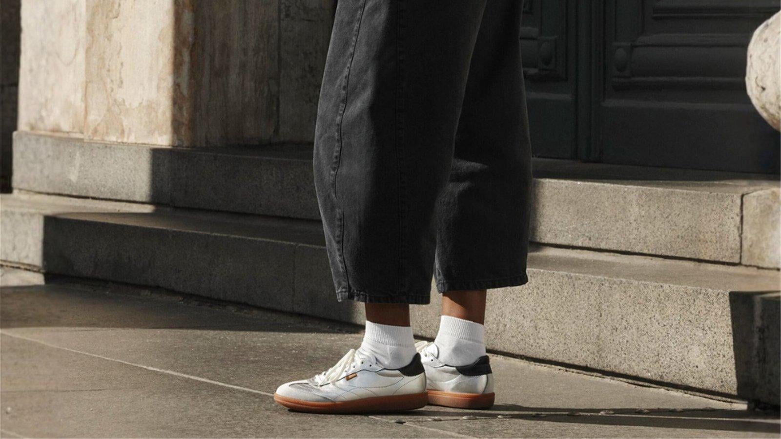 Sneaker ECCO nữ màu sáng phối quần đen bên bậc thềm