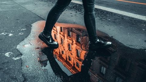 Boot da đen trên mặt đường ướt sau mưa