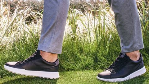 Giày golf xanh navy phối quần xám trên thảm cỏ