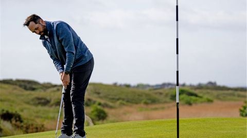 Golfer nam thực hiện cú putt cạnh cờ trên green